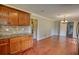 Open-concept kitchen layout with granite countertops, backsplash, wood cabinets, and hardwood floors throughout at 1177 Castle Way Way, Norcross, GA 30093