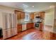 Well-lit kitchen with stainless steel appliances, wooden cabinets, granite countertops, and hardwood flooring at 1177 Castle Way Way, Norcross, GA 30093