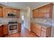 Spacious kitchen featuring granite countertops, tiled backsplash, stainless appliances, and wood cabinetry at 1177 Castle Way Way, Norcross, GA 30093