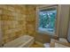 Shower featuring tiled walls and a new tub under a bright window with a tree-filled view at 1177 Castle Way Way, Norcross, GA 30093
