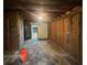 Basement with exposed framing and plywood walls leading to a room with fireplace at 2588 Sandtown Sw Rd, Marietta, GA 30060