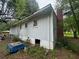Back view of a light colored home with an overgrown yard at 2588 Sandtown Sw Rd, Marietta, GA 30060