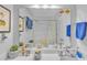 Bright bathroom with white sink, framed art above toilet, and tropical fish decor on mirror at 301 Cobblestone Trl, Avondale Estates, GA 30002
