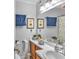 Well-lit bathroom with wood cabinets, framed art above the toilet, and a large mirror at 301 Cobblestone Trl, Avondale Estates, GA 30002
