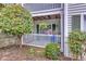 Charming front porch with white railing, lush greenery, and vibrant hanging plants at 301 Cobblestone Trl, Avondale Estates, GA 30002