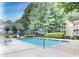 Inviting community pool with lounge chairs surrounded by mature landscaping and blue skies at 301 Cobblestone Trl, Avondale Estates, GA 30002