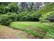 Serene backyard with a flowing creek, green lawn, and mature trees creating a peaceful environment at 3272 Pinestream Nw Rd, Atlanta, GA 30327