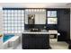 Bathroom showcases a unique vanity, classic black and white tiles, with a blue tub and glass-blocked wall at 3272 Pinestream Nw Rd, Atlanta, GA 30327