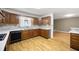 Open kitchen with warm wood cabinets, countertops, stylish backsplash, and hardwood floors extending into the living area at 3272 Pinestream Nw Rd, Atlanta, GA 30327