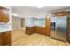 Bright kitchen with stainless steel refrigerator, wooden cabinets and light counters, open to the rest of the home at 3272 Pinestream Nw Rd, Atlanta, GA 30327