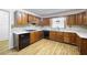 A kitchen featuring wood cabinets, white countertops, tile backsplash, and modern appliances on light hardwood floors at 3272 Pinestream Nw Rd, Atlanta, GA 30327