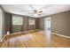 A spacious bedroom with hardwood floors, two windows with curtains and a ceiling fan at 3272 Pinestream Nw Rd, Atlanta, GA 30327
