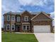 Two-story brick home featuring an attached two-car garage and a well-manicured front lawn at 365 Rodeo Dr, Auburn, GA 30011