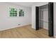 Bright bedroom featuring hardwood floors, a window with green views, and closet space at 1239 Teakwood Trl, Stone Mountain, GA 30083