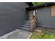Close-up of the modern front door and entryway steps with wooden handrail at 1239 Teakwood Trl, Stone Mountain, GA 30083