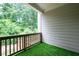 Secluded covered balcony with artificial turf and green leafy view at 203 Holden Way, Woodstock, GA 30189