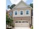 Attractive brick and siding exterior with a two-car garage and manicured landscaping at 203 Holden Way, Woodstock, GA 30189