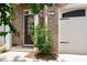 Inviting entrance with decorative plants, a partial garage door, and a well-maintained walkway at 203 Holden Way, Woodstock, GA 30189