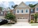 Townhome featuring a two-car garage, brick facade, and manicured lawn at 203 Holden Way, Woodstock, GA 30189