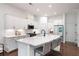 Modern kitchen boasts white cabinets, sleek countertops, stainless steel appliances and island with seating at 203 Holden Way, Woodstock, GA 30189