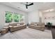 Spacious living room with multiple sofas, large windows, and a decorative ceiling fan at 203 Holden Way, Woodstock, GA 30189