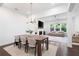 Open-concept dining and living area with modern lighting and a cozy fireplace at 203 Holden Way, Woodstock, GA 30189