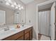 Bathroom featuring a double sink vanity with warm wood cabinets and shower with curtain at 2118 Harmony Dr, Canton, GA 30115