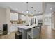 A modern kitchen features white cabinets, stainless appliances, a gray island with white countertops and pendant lighting at 2118 Harmony Dr, Canton, GA 30115