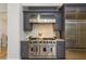 Chef's kitchen featuring a stainless steel range, custom hood, and designer backsplash at 2461 Oak Grove Ne Ests, Atlanta, GA 30345