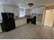Bright kitchen featuring white cabinets, stone countertops, black appliances, and tile flooring at 2670 Foxlair Trl, South Fulton, GA 30349