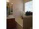 Bright bathroom featuring a soaking tub, neutral walls, and a window with natural light at 4517 Baker Grove Nw Rd, Acworth, GA 30101
