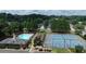 Aerial view of a community featuring a pool, tennis courts, and clubhouse nestled among mature trees at 4517 Baker Grove Nw Rd, Acworth, GA 30101