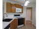 Kitchen featuring wooden cabinets, a white microwave and gas range at 4517 Baker Grove Nw Rd, Acworth, GA 30101