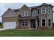 Charming two-story brick home with a well-manicured lawn and attached two-car garage at 596 Rodeo Dr, Auburn, GA 30011