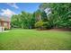 Spacious backyard with lush lawn, mature trees, and a playset, ideal for outdoor activities and enjoyment at 1360 Wilmington Way, Grayson, GA 30017