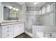 Bright bathroom featuring a white vanity with granite countertop and a walk-in shower with decorative tile accents at 1360 Wilmington Way, Grayson, GA 30017