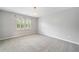 Spacious bedroom with plush carpet, neutral walls, and a window providing natural light at 1360 Wilmington Way, Grayson, GA 30017