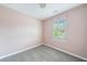Cozy bedroom featuring plush carpet, fresh paint, and natural light through a window with plantation shutters at 1360 Wilmington Way, Grayson, GA 30017