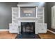 Elegant fireplace with black marble hearth and decorative white built-in shelving on either side at 1360 Wilmington Way, Grayson, GA 30017