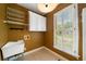 Functional laundry room features storage cabinets, wire shelving, large window with shutters and a utility sink at 1360 Wilmington Way, Grayson, GA 30017