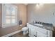 Inviting powder room with granite countertop, white cabinetry, and a window for natural light at 1360 Wilmington Way, Grayson, GA 30017