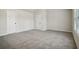 This bedroom features two doors, light colored walls, neutral carpet and a large window at 606 Rodeo Dr, Auburn, GA 30011