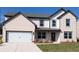 Charming two-story home with a brick facade, attached garage, and professionally landscaped front yard at 606 Rodeo Dr, Auburn, GA 30011