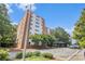 Exterior view of the apartment building with parking; lush trees at 2965 Pharr Nw Ct # 714, Atlanta, GA 30305
