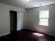 Bright bedroom with dark hardwood floors, natural light from the window, and closet with sliding doors at 210 Ormond Sw St, Atlanta, GA 30315