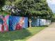 Colorful murals painted on a row of industrial containers alongside a walking path at 215 Arizona Ne Ave # 3, Atlanta, GA 30307