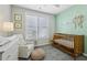 A charming Bedroom room with soft green accents, a crib, and a comfortable rocking chair at 215 Arizona Ne Ave # 3, Atlanta, GA 30307
