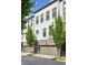 Modern townhome showcasing white brick, gray trim, garage, and manicured trees at 215 Arizona Ne Ave # 3, Atlanta, GA 30307