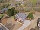 Aerial view of the home with a brick facade, mature trees, and a large front yard at 410 Hickory Fairway Ct, Woodstock, GA 30188