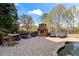 Backyard brick patio features an outdoor stone fireplace and a beautiful kidney shaped pool with stone surround at 410 Hickory Fairway Ct, Woodstock, GA 30188